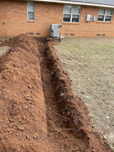 A pile of dirt next to a brick house