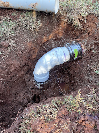 A pipe laying in the ground next to a pipe