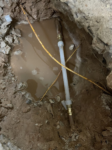 A pipe sticking out of a hole in the ground