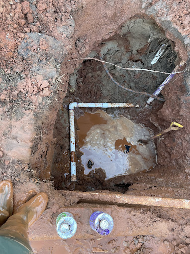 There is a hole in the ground with a pipe in it