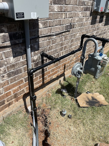 A couple of pipes that are next to a brick wall