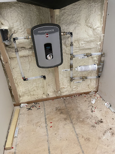 A water heater installed in the wall of a bathroom