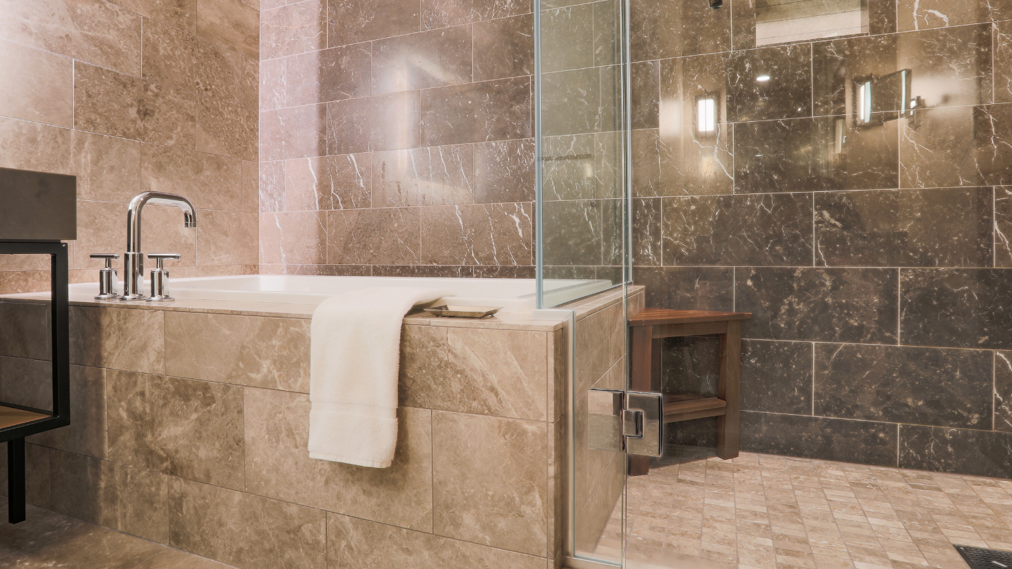 A bathroom with a bathtub and a chair