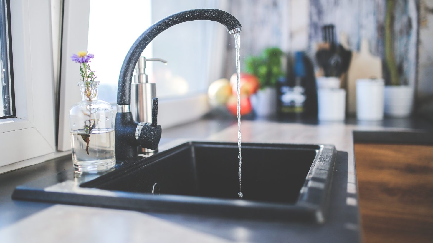 A kitchen sink with a faucet running water